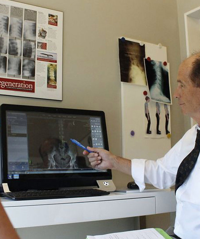 Doctor at Leucadia Chiropractic & Disc Injury Clinic examining patient x-rays for spine injury