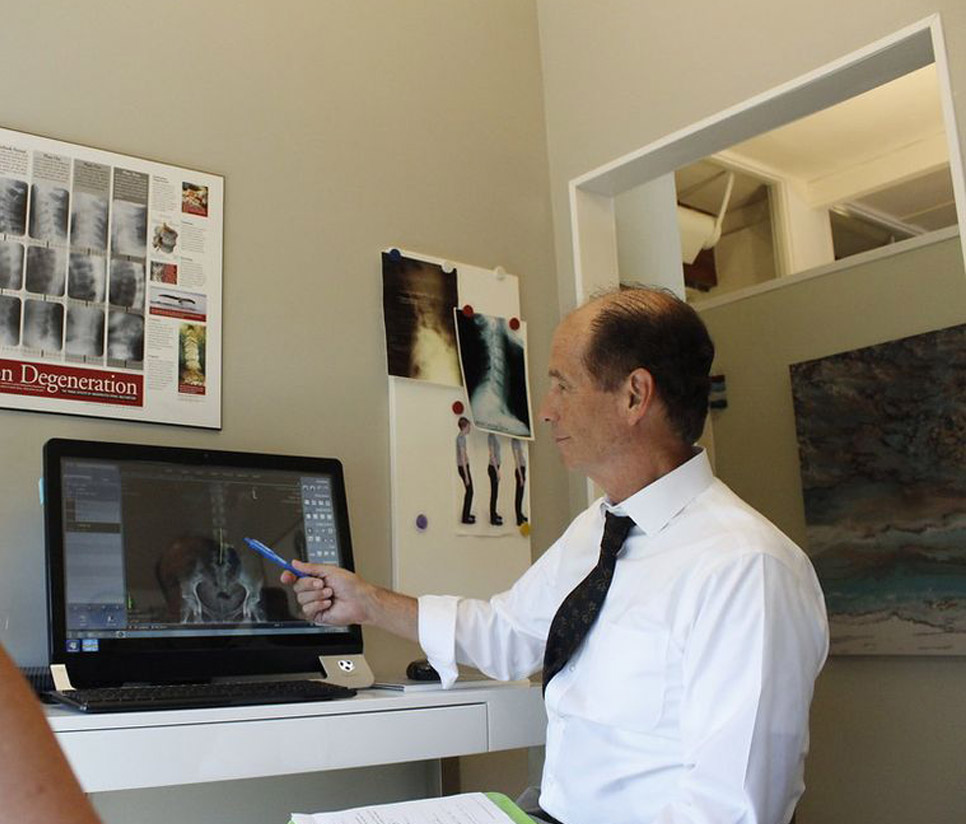 Doctor at Leucadia Chiropractic & Disc Injury Clinic examining patient x-rays for spine injury